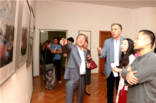 中国国家画院国画院副院长于文江向黑山名誉总统武亚诺维奇介绍展览作品